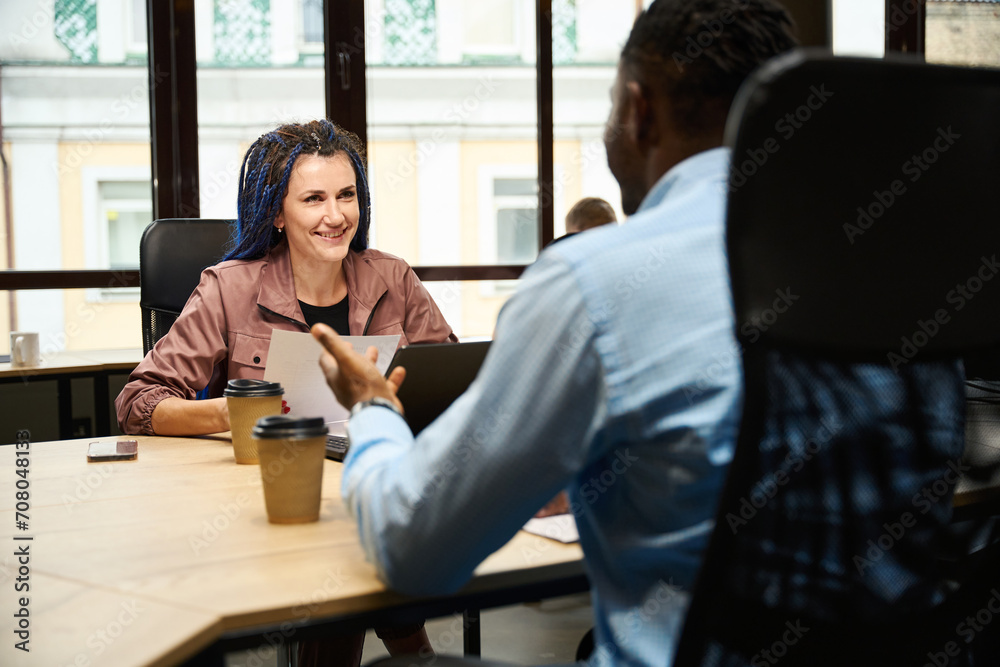 African American man flirting with his caucasian colleague with braided hair