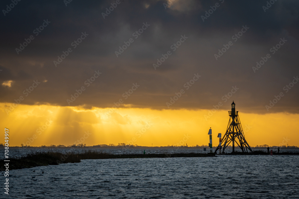 Sunset scenery with lighthouse of Hoorn in silhouette, Province North Holland, The Netherlands