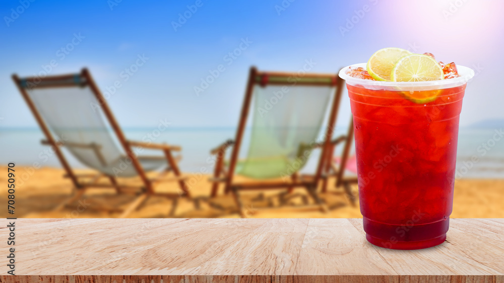 Iced tea and lemon slices on wooden table with beach landscape nature background, Summer drinks with ice