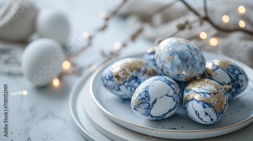 white blue eggs with gold patterns, blue marble in a beautiful plate on a white table with decor, Easter, quiet luxury style photo
