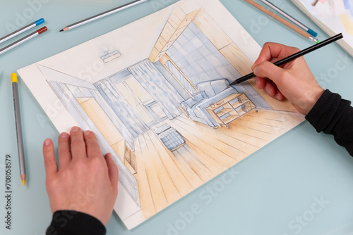 Interior designer is working on color hand drawing of cosy living room using a black pencil