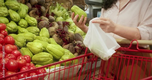 Woman buys food, machucho in the market, in the supermarket. Girl chooses products,vegetables, fruits in the store. Caiota from the Cucurbitaceae family, is a vegetable known by the names of chayote, photo