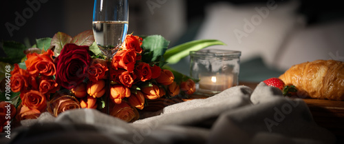 Breakfast with red roses and champagne on bed. Romantic background for valentins day ore mothers day.