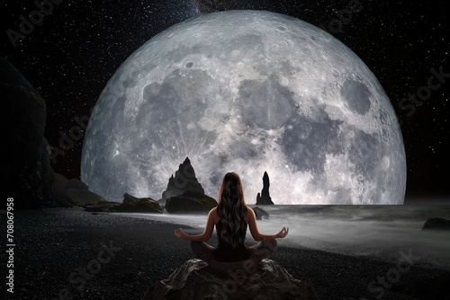 Woman in yoga position in front of the full moon