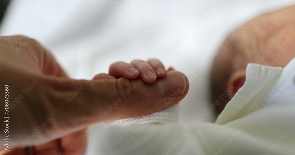 Newborn baby holding father finger during first day of life Newborn baby holding father finger during first day of life