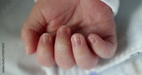 Newborn baby infant asleep, close-up of tiny little hand in macro detail
