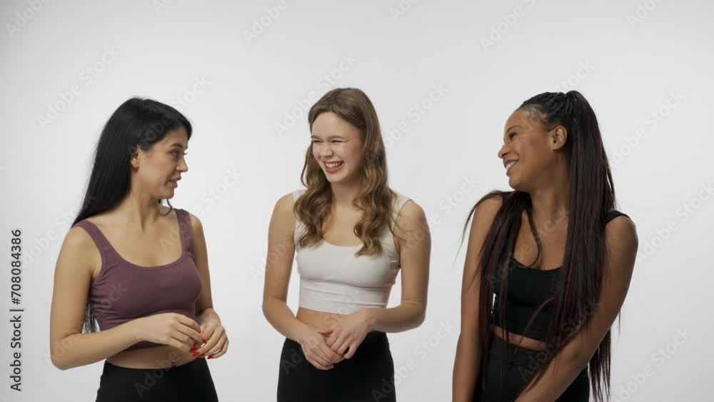 Portrait of young multiethnic models on white background close up. Group of three beautiful multiracial girls talking hugging smiling at camera. Multiethnic beauty concept. Portrait of young multiethnic models on white background close up. Group of three beautiful multiracial girls talking hugging smiling at camera. Multiethnic beauty concept.