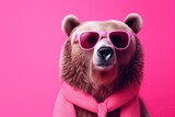 photo Brown bear portrait with pink glasses. banner with pink Peach Fuzz background