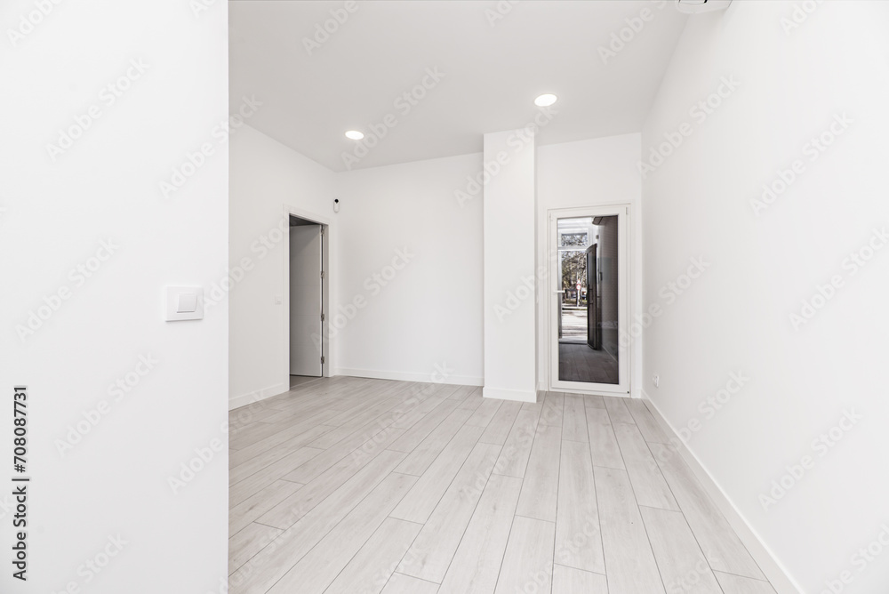 Obraz premium A newly installed loft-style home with light gray parquet floors, glass and white aluminum doors