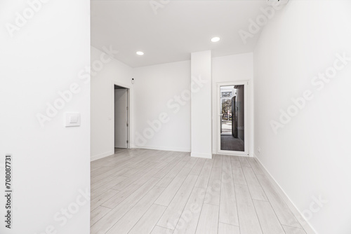 A newly installed loft-style home with light gray parquet floors  glass and white aluminum doors