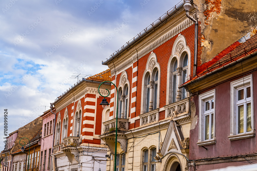 Red and White Building With Clock in Brasov, Romania. A vibrant red and white building adorned with a clock, standing in Brasov, Romania, inviting travelers to explore Transylvania.