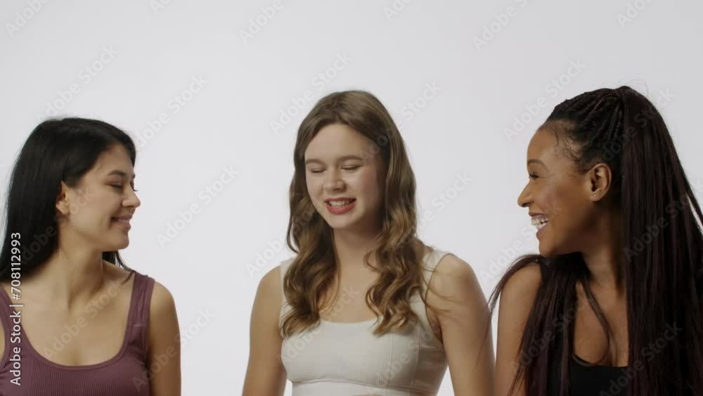Portrait of multiethnic female models isolated on white background, close shot. Group of three multiracial girls posing at the camera, smiling. Multiethnic beauty concept.