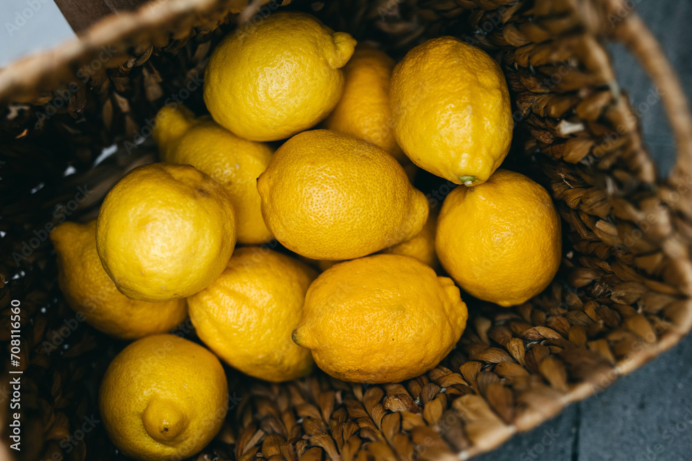 Bright lemons nestled in a woven basket.