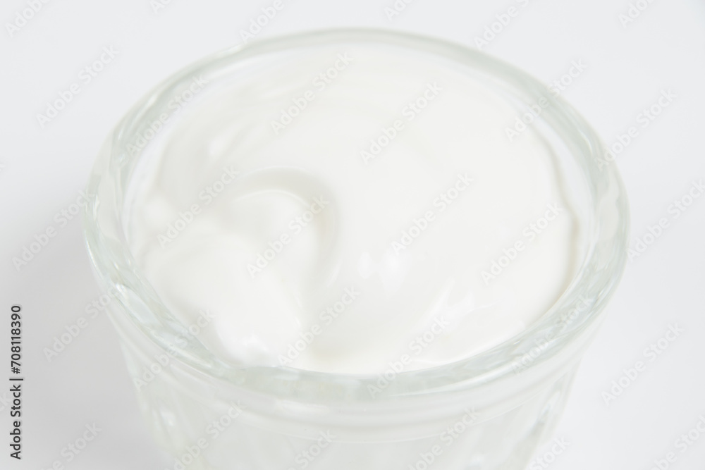 Sour cream in a glass saucer on a white background Sour cream in a glass saucer on a white background