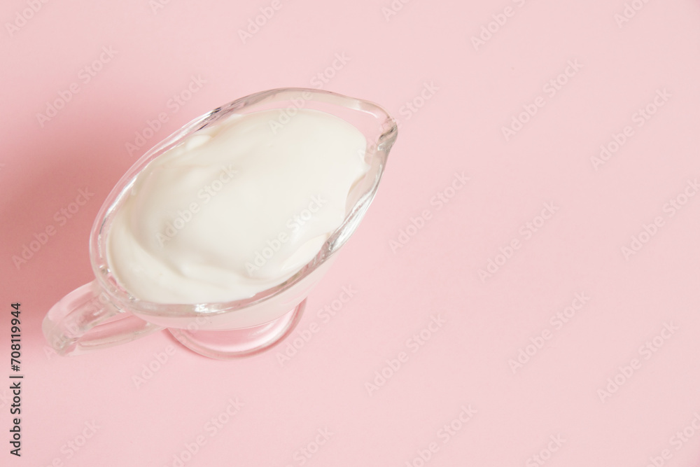 White sauce in a glass saucer on a pink background White sauce in a glass saucer on a pink background