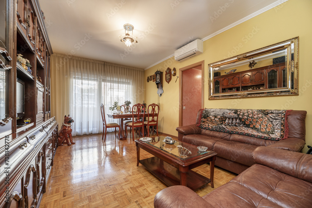 Living room of a house with classic style wooden furniture with a dining table with matching chairs