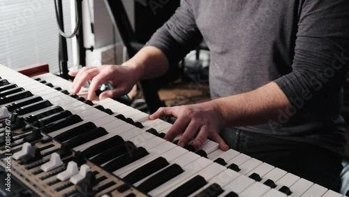Man hands playing pia no keyboard with passion. Musician perfomance with classical music indoors on pianoforte photo