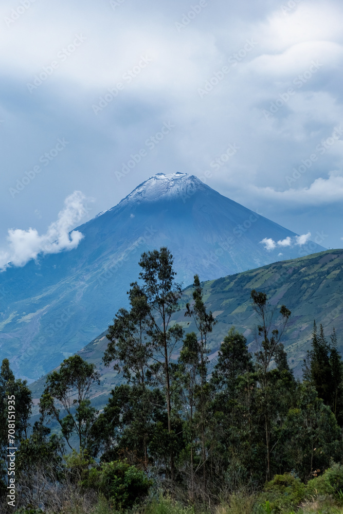 Volcano with its snow-capped crater amidst clouds