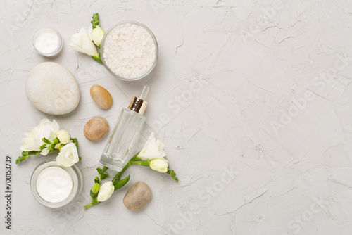 Flat lay with spa products and flowers on concrete background