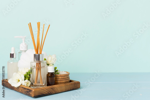 Spa composition with freesia flower and aroma diffuser on wooden table photo