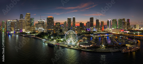 American urban landscape at night. Miami marina and Skyviews Observation Wheel at Bayside Marketplace with reflections in Biscayne Bay water and skyscrapers of Brickell  city s financial center