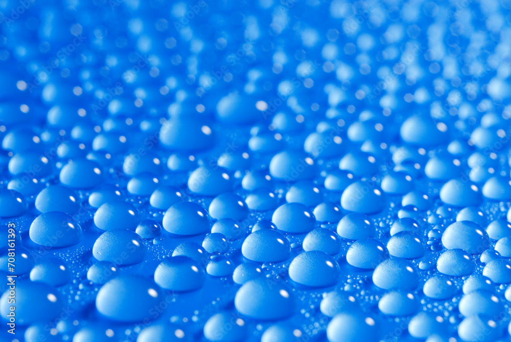 closeup, macro of many water drops, droplets, on a blue surface, background
