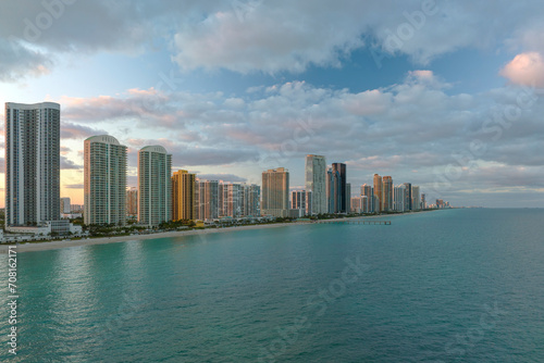 Expensive highrise hotels and condos over sandy beachfront on Atlantic ocean shore in Sunny Isles Beach city at sunset. American tourism infrastructure in southern Florida