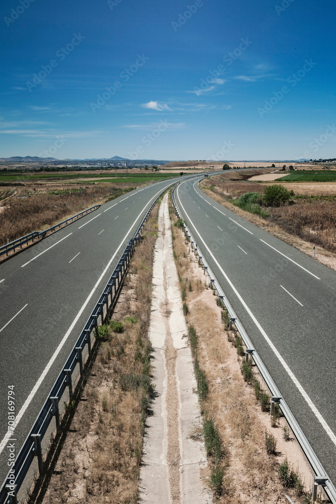 Roads parallel to the horizon in the background of the photograph, with vegetation and signage. Roads parallel to the horizon in the background of the photograph, with vegetation and signage.