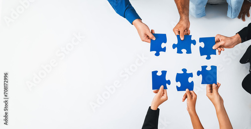 Top view panorama banner of business team joining jigsaw puzzle together over meeting table symbolize business partnership and collective unity teamwork in problem solving solution. Prudent © Summit Art Creations