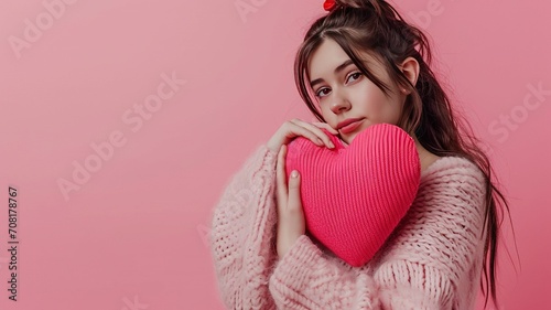 Portrait of a young beautiful, fashionable, romantic girl who has a big pink heart. Minimal Valentine's Day symbol of love