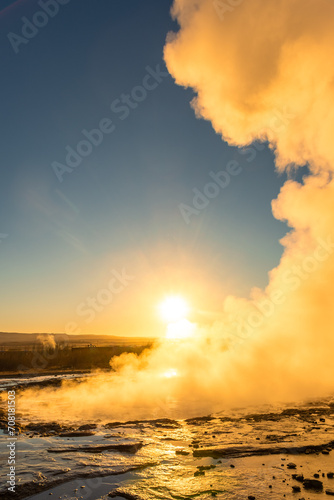 Stokkur geyser spectacular eruption in front of the sun , Iceland