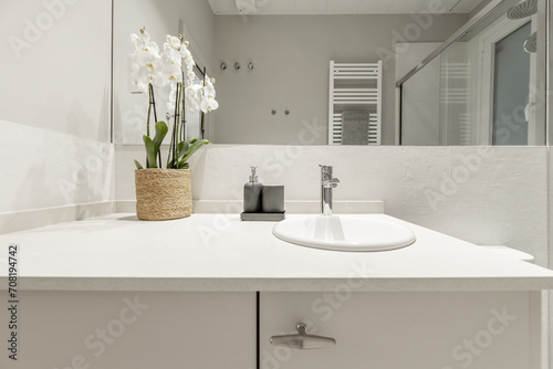 a modern design bathroom with mirrors integrated into the wall and beige stone countertop on wooden furniture