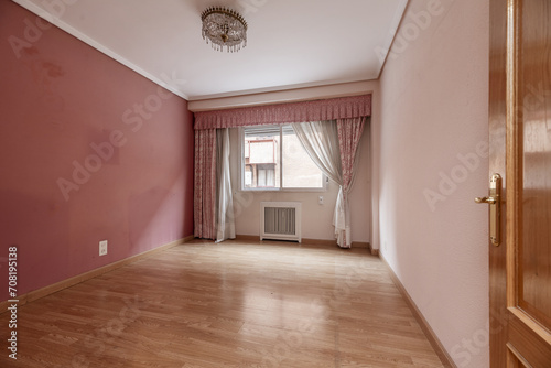 Living room with terracotta and pale pink walls, oak carpentry on doors and floors, curtains and curtains with matching skirts