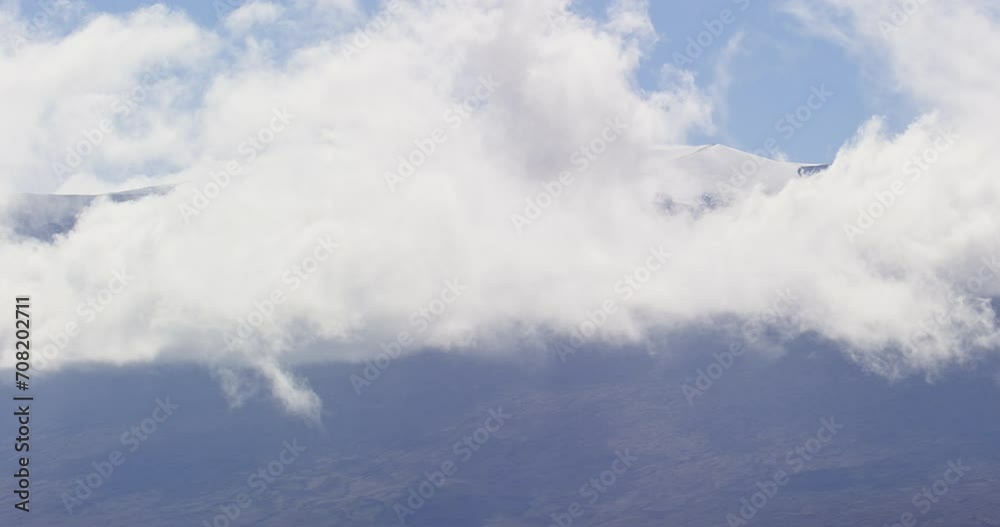 Snow covered mountain top hidden behind rolling white clouds. Snow covered mountain top hidden behind rolling white clouds.