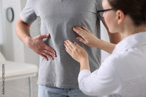 Foto Gastroenterologist examining patient with stomach pain in clinic