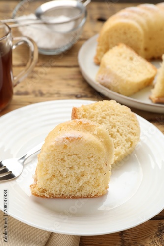 Pieces of delicious sponge cake on wooden table, closeup
