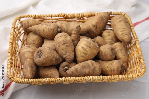 Foto Tubers of turnip rooted chervil in wicker basket on table, closeup