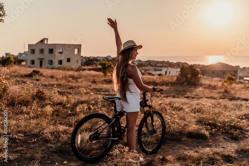 A woman cyclist on a mountain bike looking at the landscape sea. Adventure travel on bike.