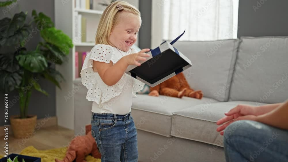 Caucasian mum and little girl surprising each other with birthday gifts, in the cozy living room of their home. two generations celebrating a special moment. Caucasian mum and little girl surprising each other with birthday gifts, in the cozy living room of their home. two generations celebrating a special moment.
