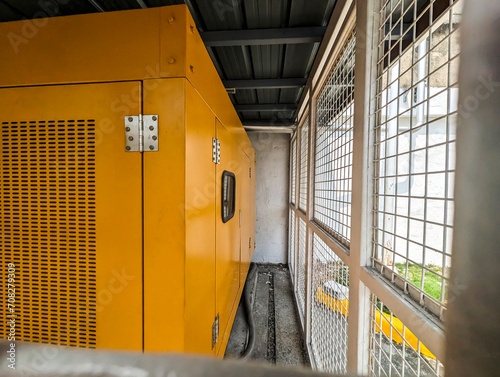 An enclosed commercial backup generator for a business establishment. Placed outdoor and inside a steel cage for security and protection.