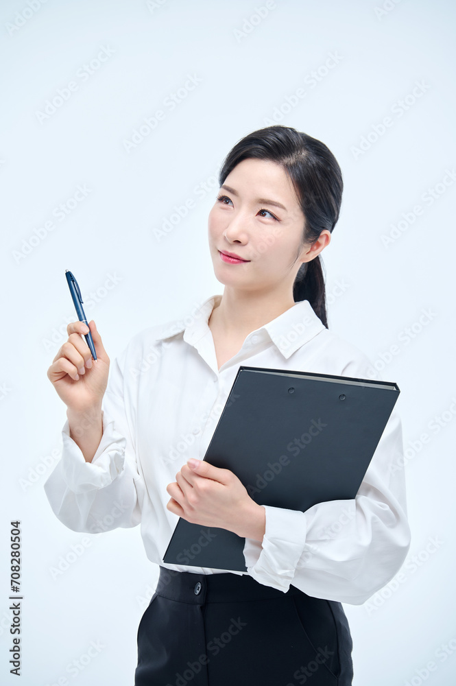 A beautiful Asian woman is making various facial expressions and gestures while holding a document file and a ballpoint pen for business. A beautiful Asian woman is making various facial expressions and gestures while holding a document file and a ballpoint pen for business.