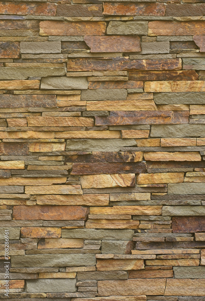 Texture of a stone wall from long and rough stones of different sizes and tones
