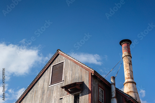 A classic designed wooden shelter or warehouse with blue sky in day time as background. Industrial building place.