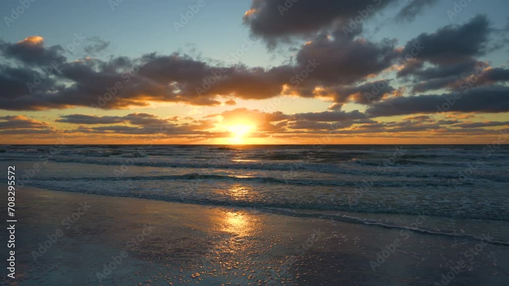 Evening landscape of sea water waves crushing on sandy beach at sunset Evening landscape of sea water waves crushing on sandy beach at sunset
