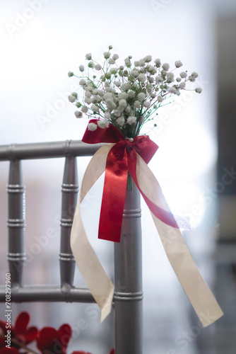 white chair with red and white flowers decoration in wedding ceremony