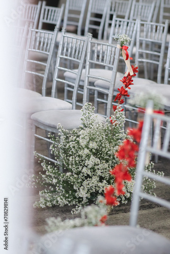 white chair with red and white flowers decoration in wedding ceremony