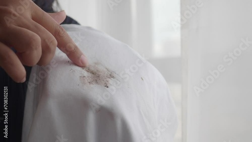  women holding white color dirty shirt, showing making stain photo