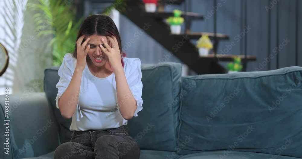 Indian Asian Hindu lonely anxious unhappy young female burst of anger feel bad upset sitting alone on sofa couch at home. tensed sad angry woman lady suffers money issues regret mistake indoor house Indian Asian Hindu lonely anxious unhappy young female burst of anger feel bad upset sitting alone on sofa couch at home. tensed sad angry woman lady suffers money issues regret mistake indoor house