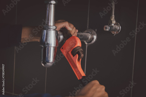 plumber at work in a bathroom, plumbing repair service , fix water plumbing leaks, replace the kitchen sink drain