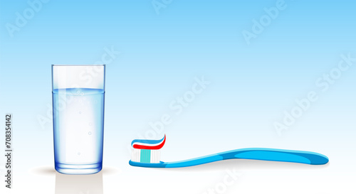 A blue toothbrush with a multi-colored paste located at the bottom and a transparent glass cup on a blue gradient background. Dental concept. Copy space.